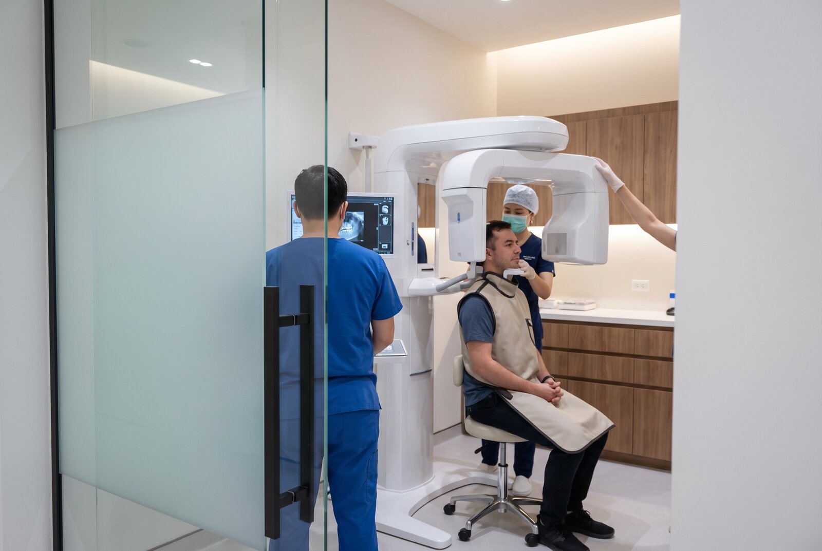 Patient positioned at a dental cone beam scanner during an implant planning visit at a Reseda dental office