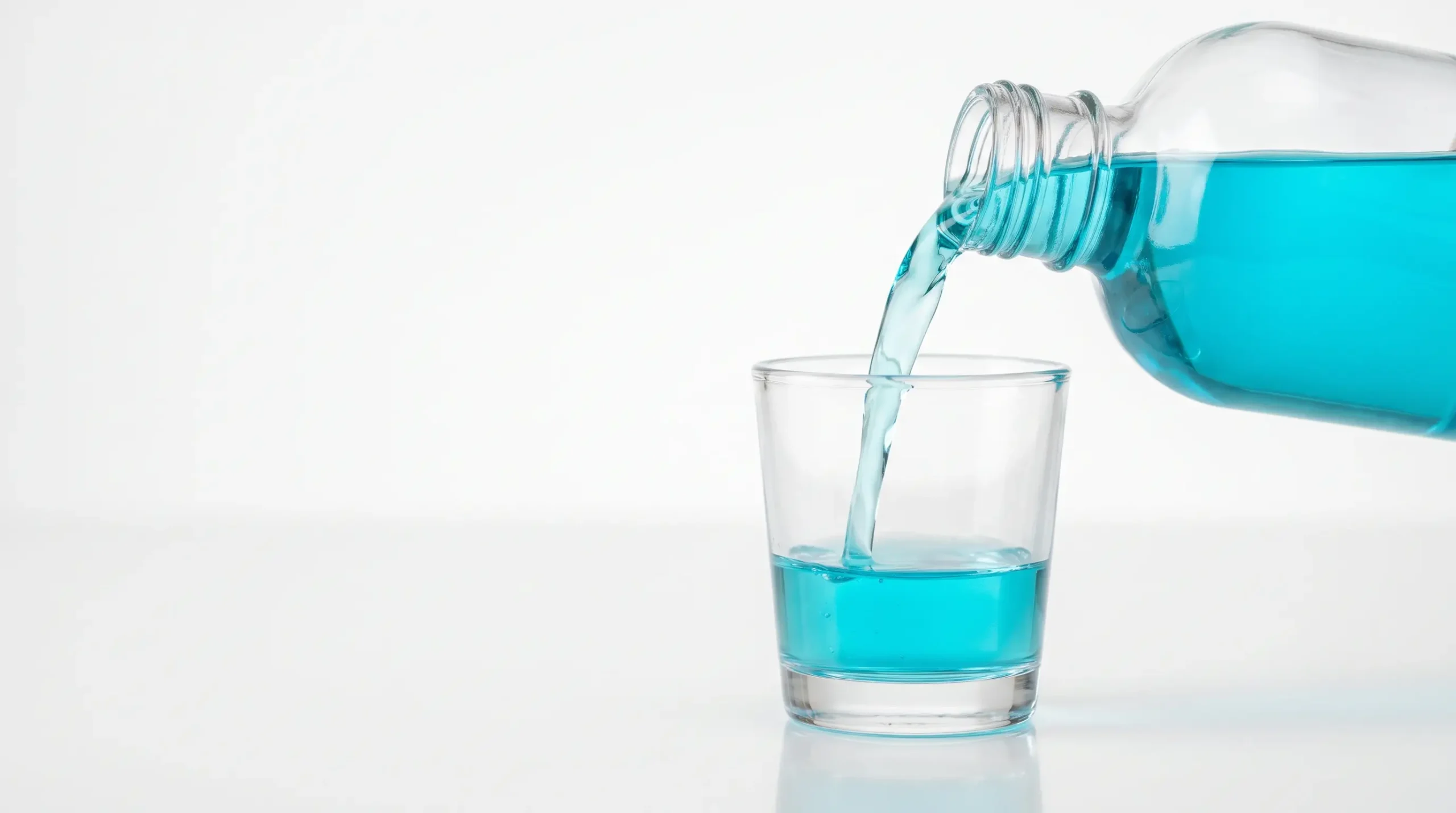 Mouthwash being poured into a cup as part of a routine to fix halitosis